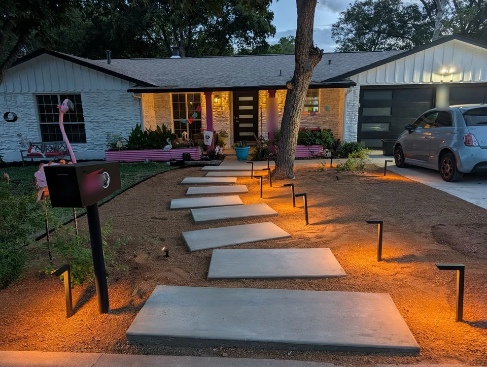 Floating concrete steps leading to the front porch, lit at dusk