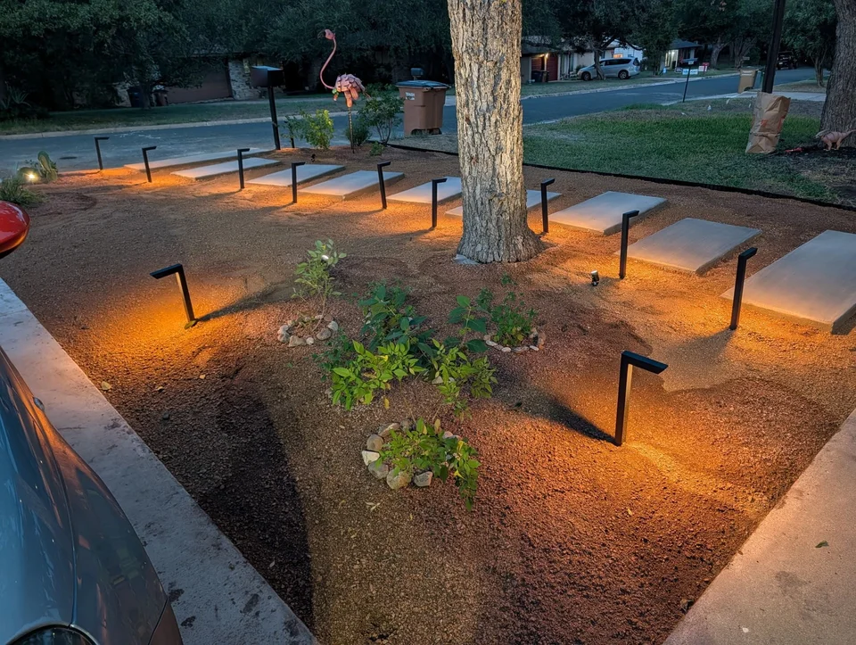 Floating steps, new plantings, and path lights viewed from the yard toward the street